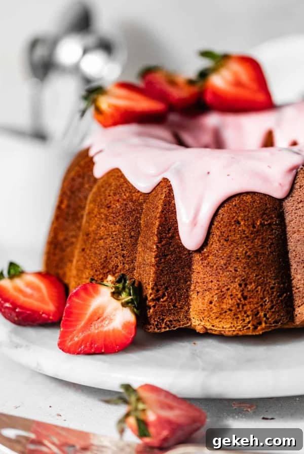 Moist Lemon Blueberry Pound Cake Recipe 11 strawberry pound cake on a serving tray garnished with fresh strawberries and strawberry glaze.