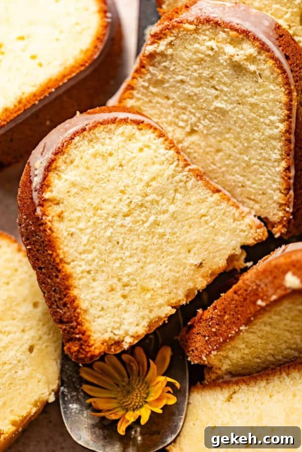Moist Lemon Blueberry Pound Cake Recipe 12 lemon cream cheese pound cake sliced on a serving tray and topped with cream cheese glaze.