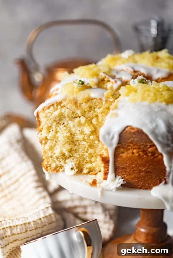 Moist Lemon Blueberry Pound Cake Recipe 13 sliced pineapple pound cake on a cake stand covered in a pineapple glaze and topped with crushed pineapples.