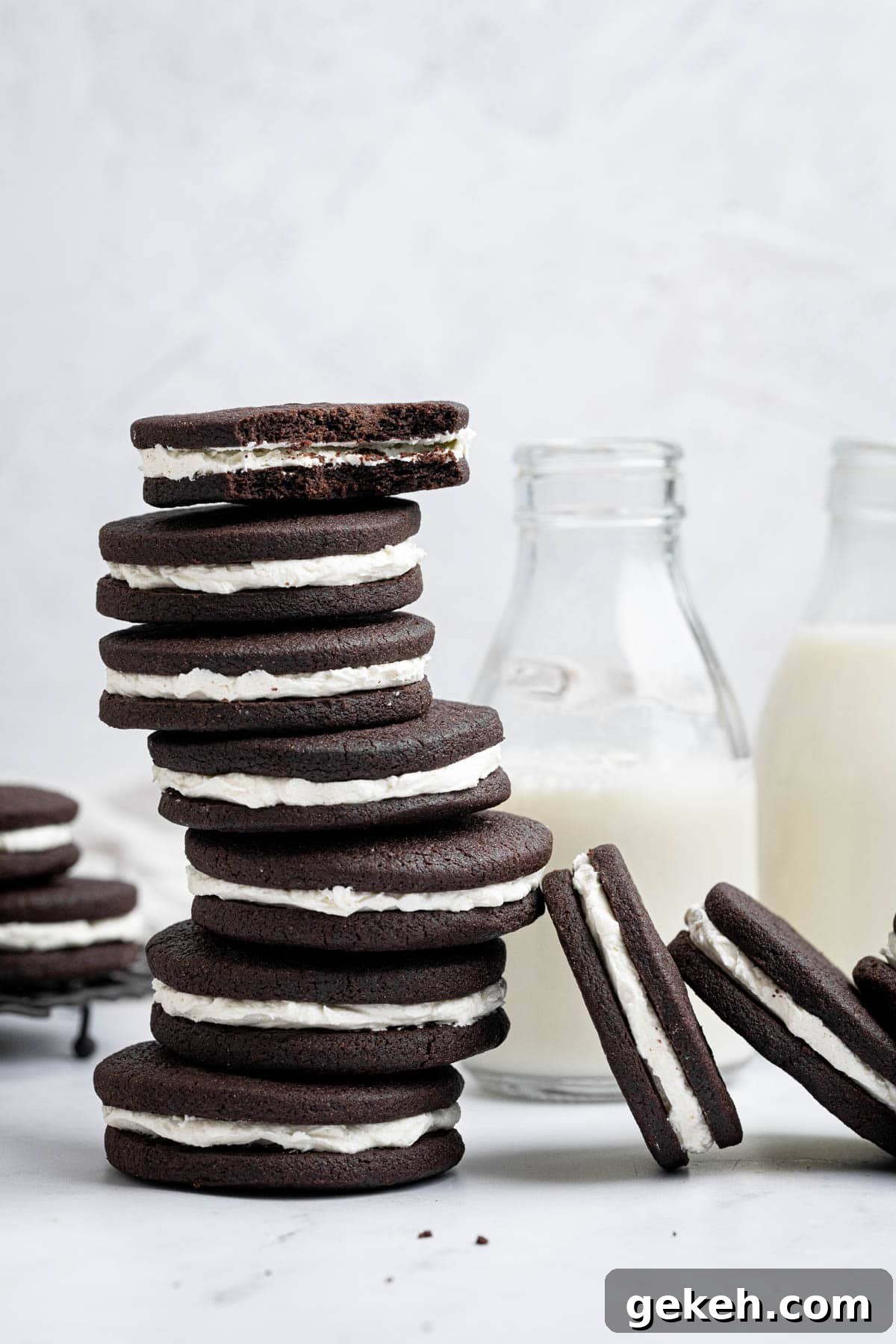 Vegan Mint Chocolate Sandwich Cookies Recipe 2 A stack of vegan mint chocolate sandwich cookies next to a couple of milk bottles.