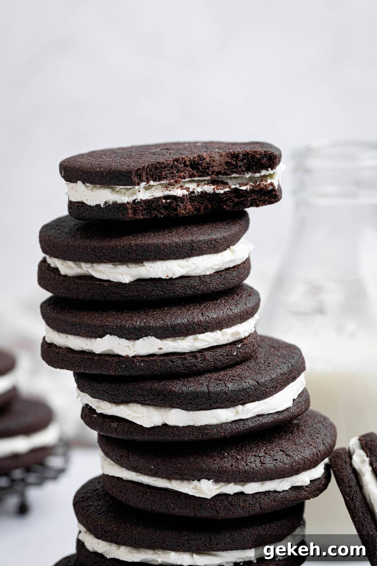 Vegan Mint Chocolate Sandwich Cookies Recipe 12 Close up of a stack of mint chocolate sandwich cookies, the top one with a bite taken out of it.