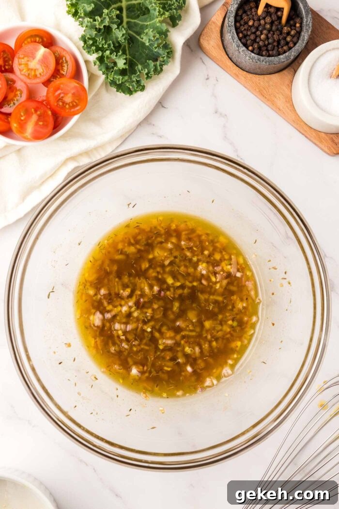 Protein-Packed Lentil and Kale Salad with Lemon Tahini Dressing 5 A shallot and garlic vinaigrette mixed together in a large glass mixing bowl.