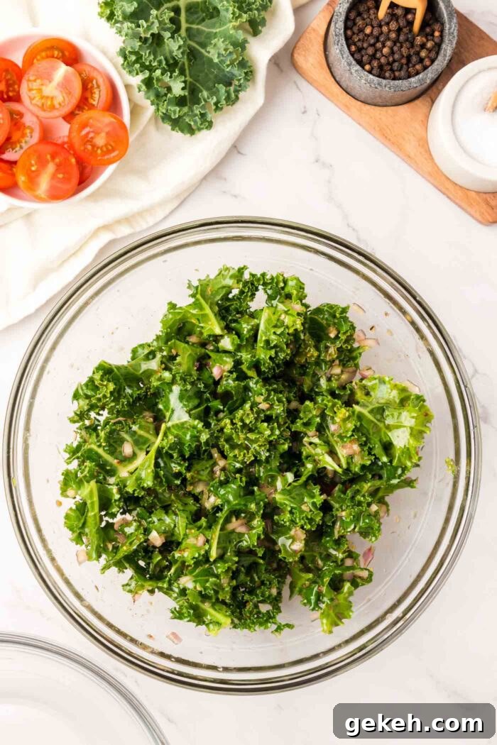 Protein-Packed Lentil and Kale Salad with Lemon Tahini Dressing 6 Kale mixed with dressing in a large mixing bowl.