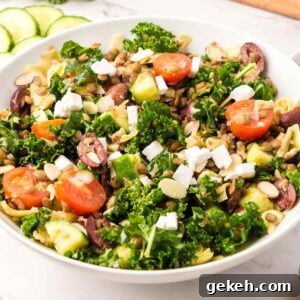 Protein-Packed Lentil and Kale Salad with Lemon Tahini Dressing 9 A large bowl of a kale salad with lentils, cucumber, feta, tomato and olives.