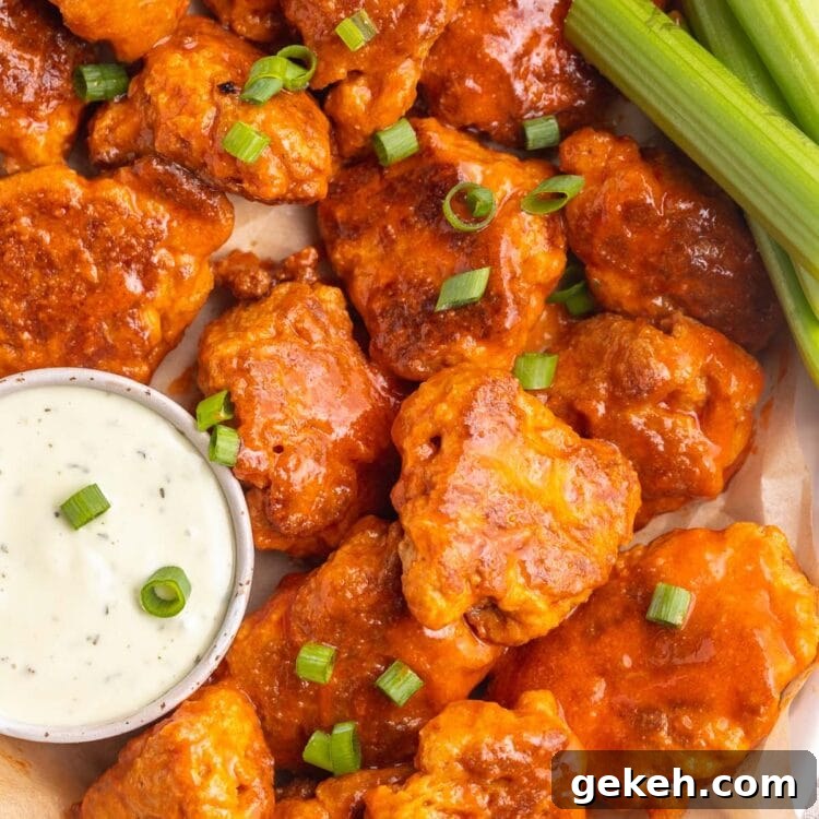 Buffalo-Style Seitan Wings with Spicy Vegan Sauce 5 Buffalo sauced seitan wings on a platter with ranch dressing and celery.