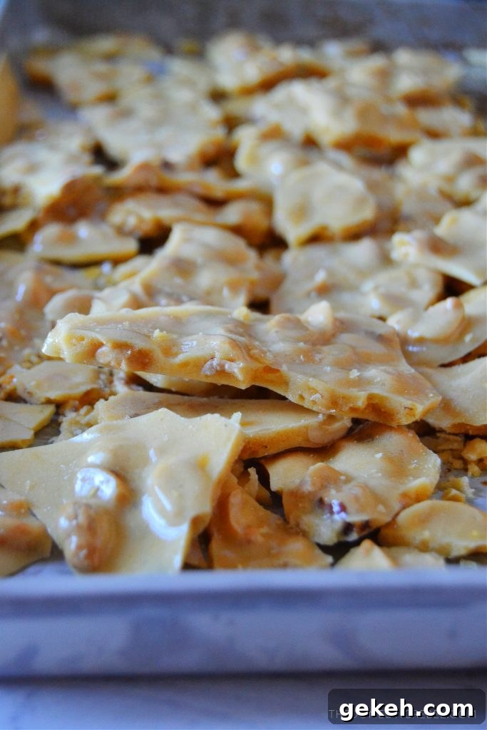 peanut brittle pieces scattered on a silver jelly roll pan