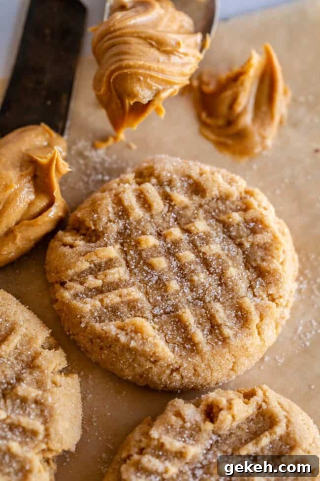 Chewy Peanut Butter Cookie Recipe That Melts in Your Mouth 6 easy peanut butter cookie on a tray, with a scoop of peanut butter on the side.