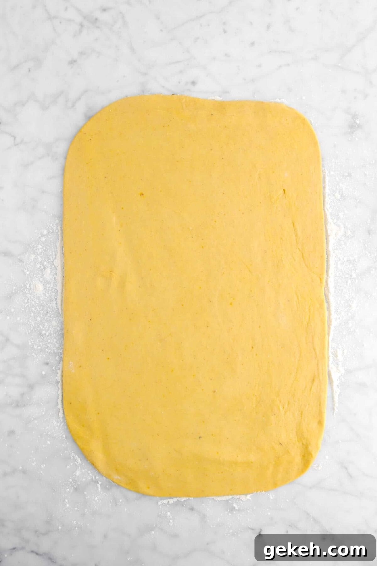 pumpkin dough rolled out on marble counter