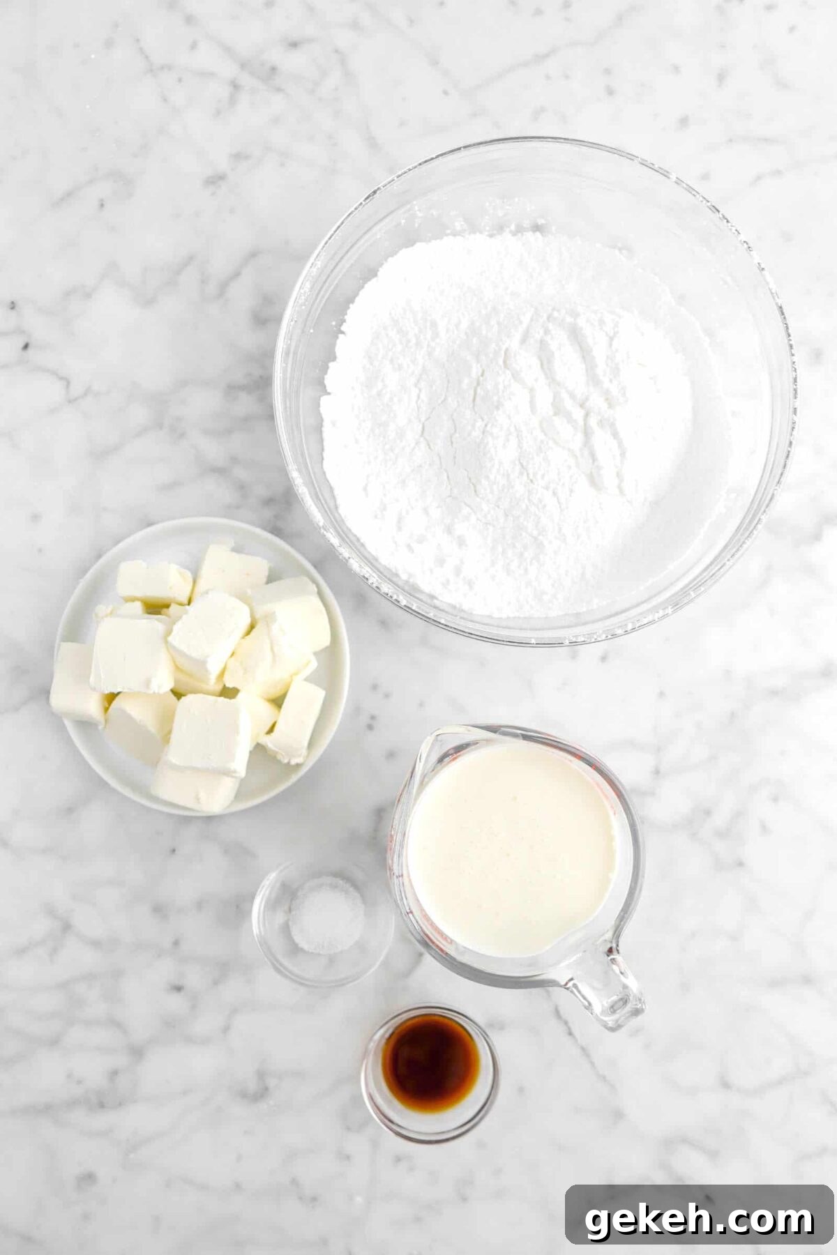 powdered sugar, cream cheese, heavy cream, salt, and vanilla on marble counter