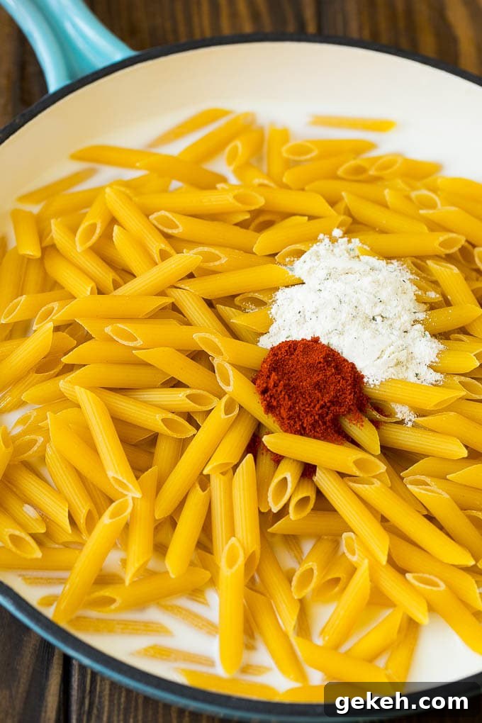 Buffalo Chicken Pasta Recipe | Baked Pasta #chicken #buffalochicken #pasta #cheese #dinner #dinneratthezoo Penne pasta with seasonings in a pan of milk.