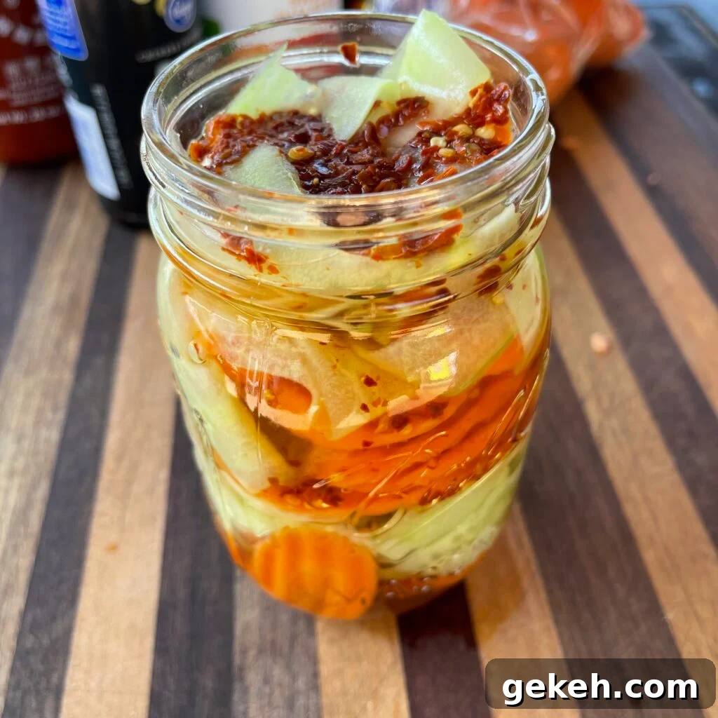 Thai-Style Grilled Chicken with Tangy Marinade 6 mason jar with carrot and cucumber pieces and pickling brine.
