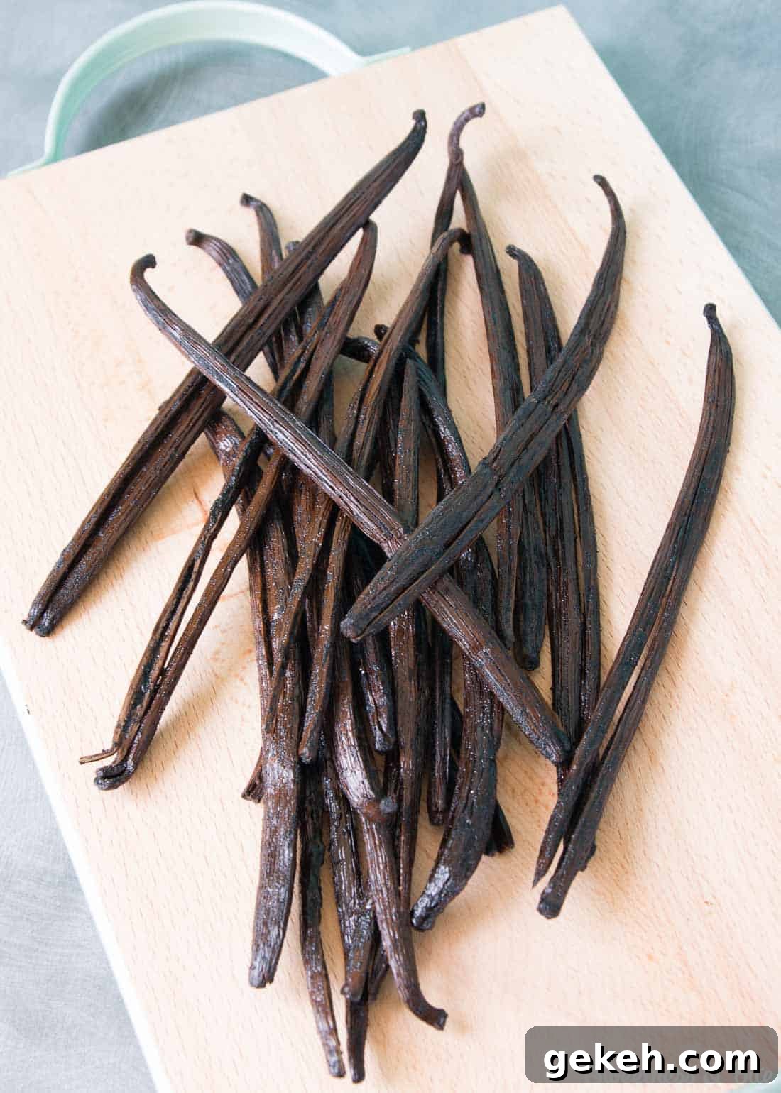 Homemade Vanilla Extract Infused with Rum: Step-by-Step Guide 4 A pile of plump vanilla beans on a wooden chopping board.