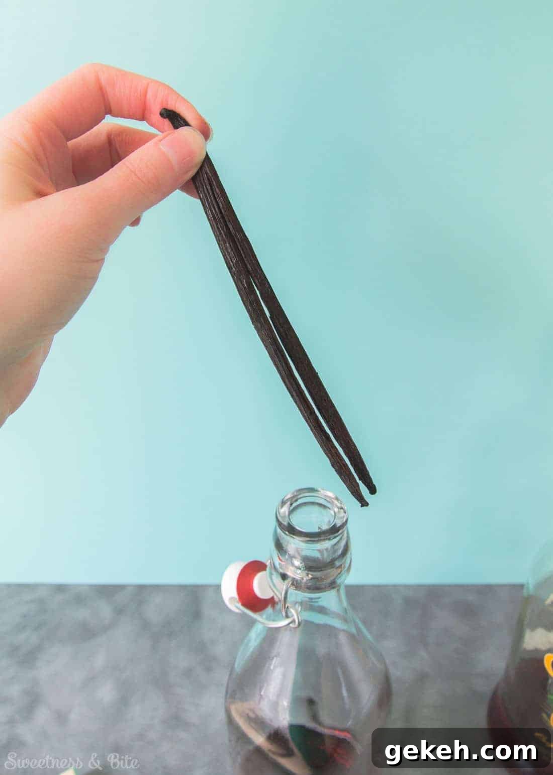 Homemade Vanilla Extract Infused with Rum: Step-by-Step Guide 6 A vanilla bean being put into the bottle, split end down.