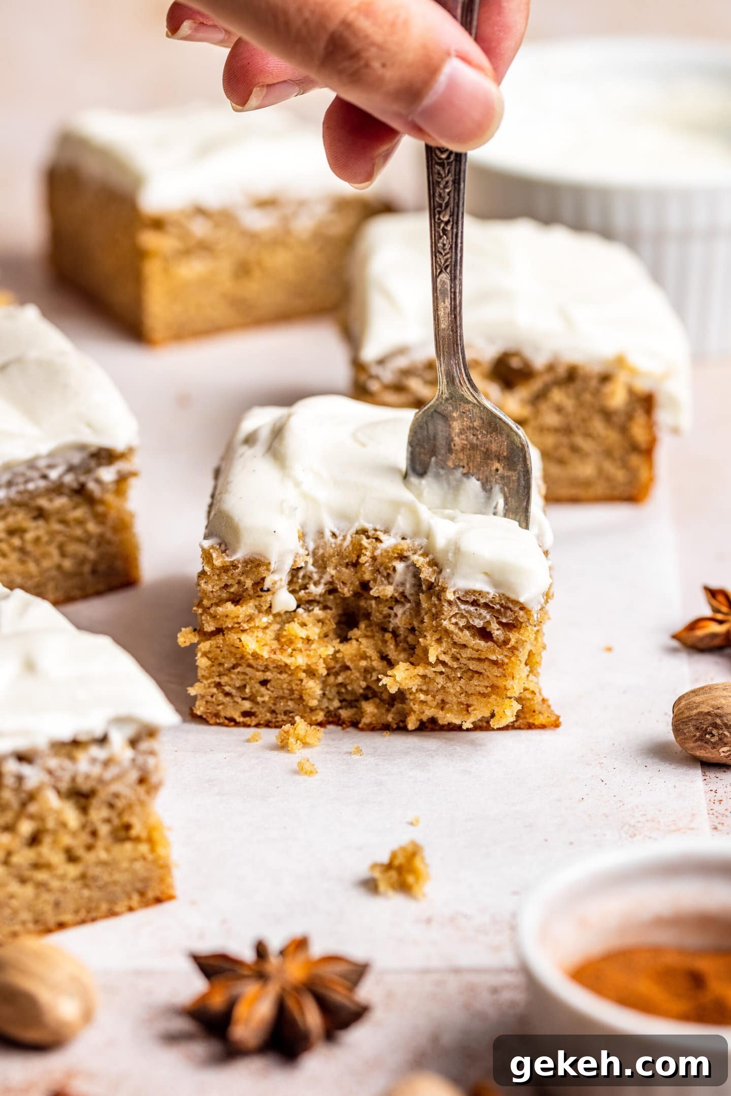 Spiced Banana Snack Cake Recipe for Moist, Flavorful Bites 7 Hand holding fork digging into slice of Spiced Banana Snack Cake with bite already missing