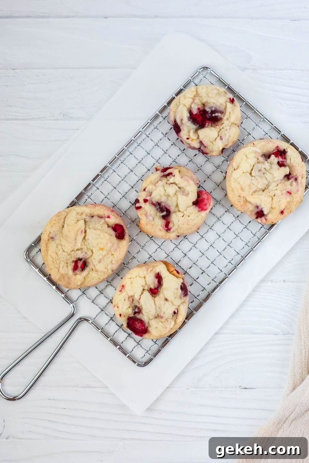overhead view of five cranberry orange cookies, without icing, on a wire rack.