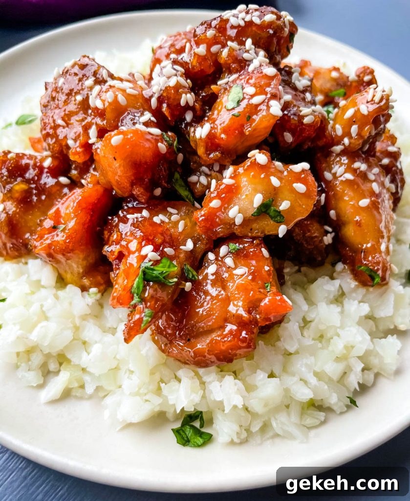 Keto Orange Chicken: Low-Carb Sticky Citrus Chicken Recipe 13 keto low carb orange chicken on a white plate with sesame seeds