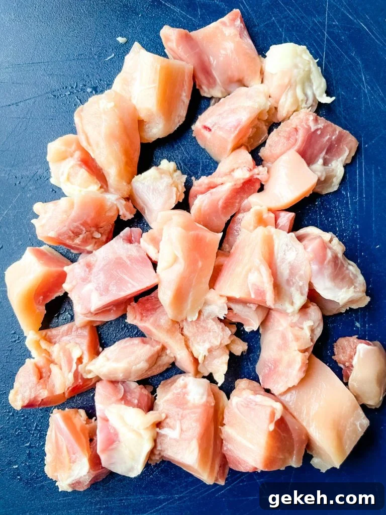 Keto Orange Chicken: Low-Carb Sticky Citrus Chicken Recipe 5 raw chicken thighs sliced on a cutting board