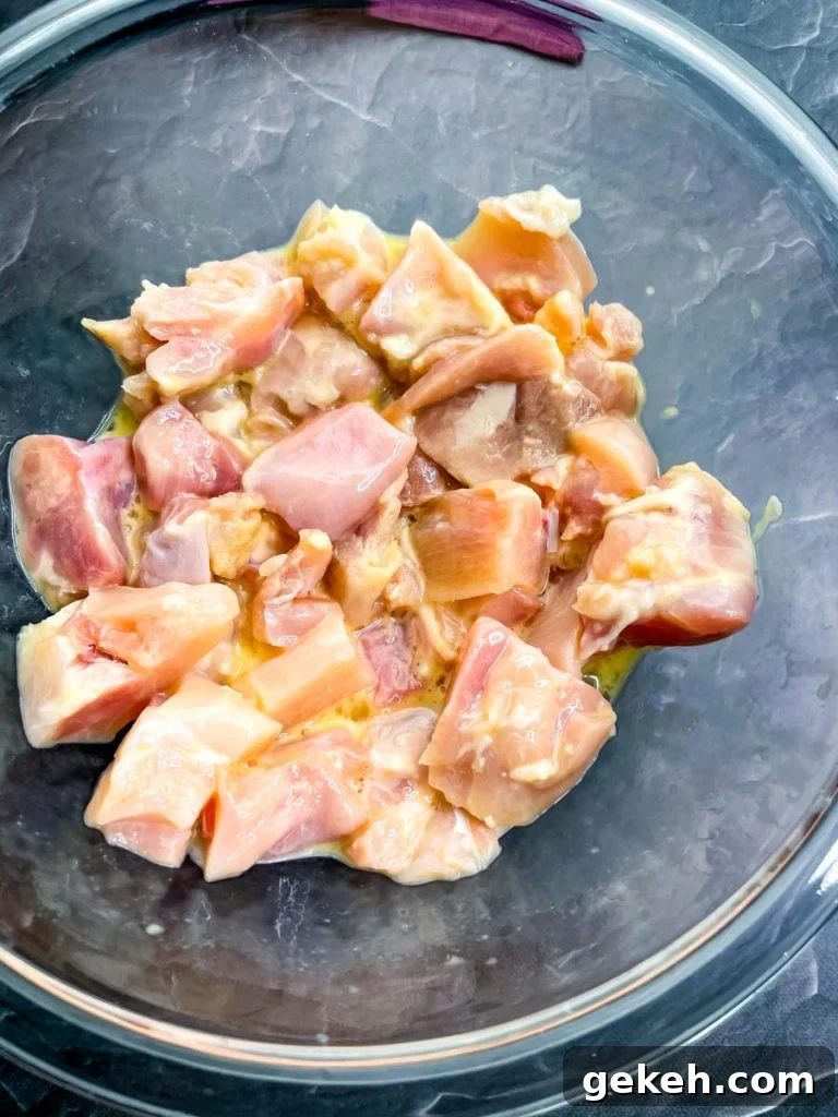 Keto Orange Chicken: Low-Carb Sticky Citrus Chicken Recipe 7 raw chicken thighs in a glass bowl with raw eggs and baking powder