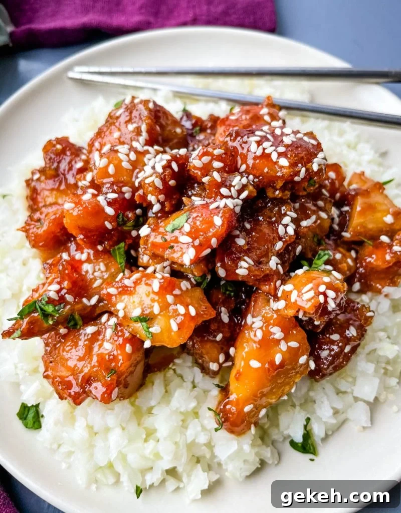 Keto Orange Chicken: Low-Carb Sticky Citrus Chicken Recipe 10 keto low carb orange chicken on a white plate with sesame seeds