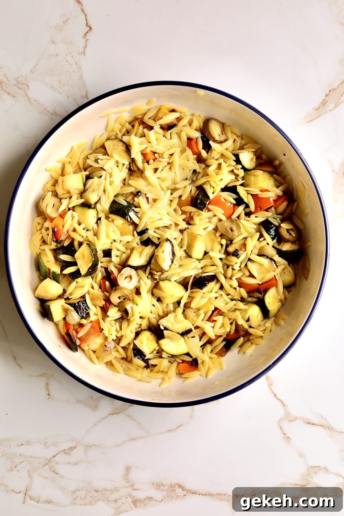 Roasted Vegetable and Parmesan Orzo Recipe 9 How to make Easy Orzo Pasta with Roasted Vegetables and Parmesan- mixing all the ingredients together with the cooked pasta.