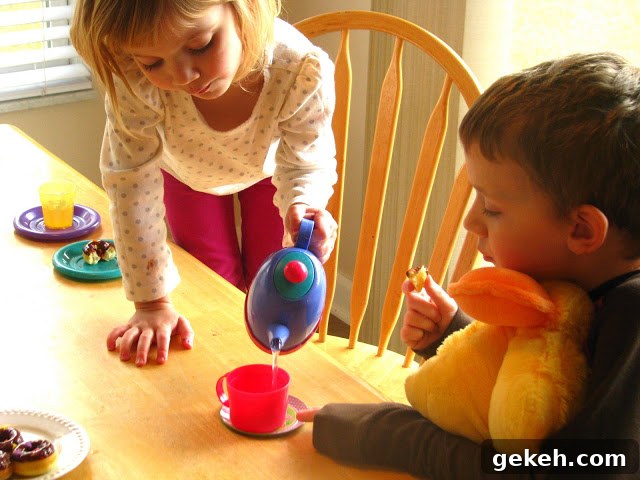 child pouring water from toy tea pot