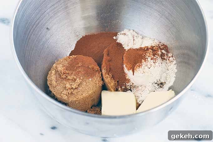 Classic Old-Fashioned Crumb Cake Recipe: Timeless Coffee Cake Delight 12 Packed brown sugar, cinnamon, flour, and butter in a stainless steel mixing bowl, on a marble background.