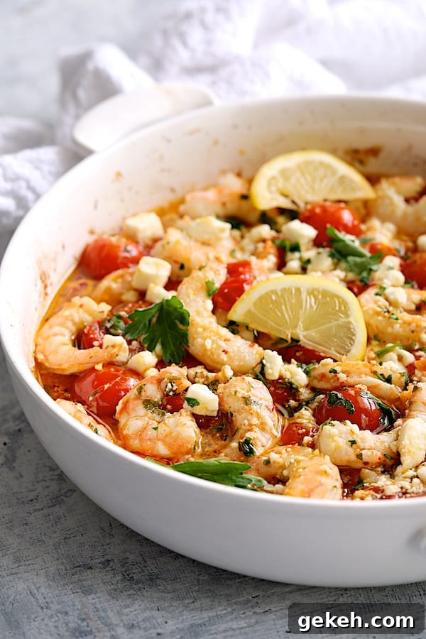 Photo of Spicy Baked Shrimp with Tomatoes and Feta Cheese garnished with parsley and lemon.