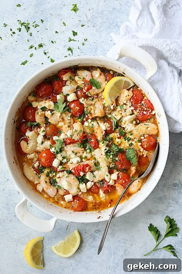 Photo of Spicy Baked Shrimp with Tomatoes and Feta Cheese on light blue background garnished with lemon and parsley.