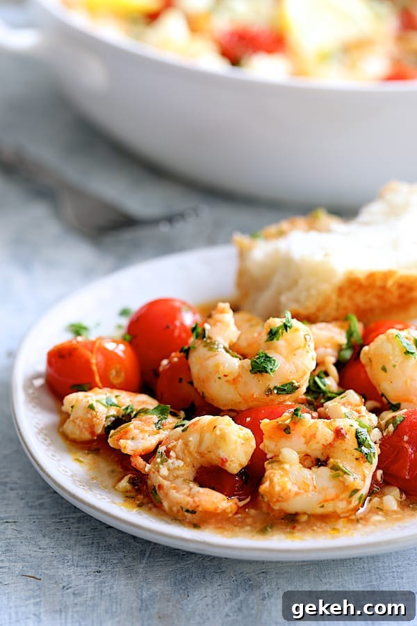 Photo of one serving of Spicy Baked Shrimp with Tomatoes and Feta Cheese on white plate with bread.