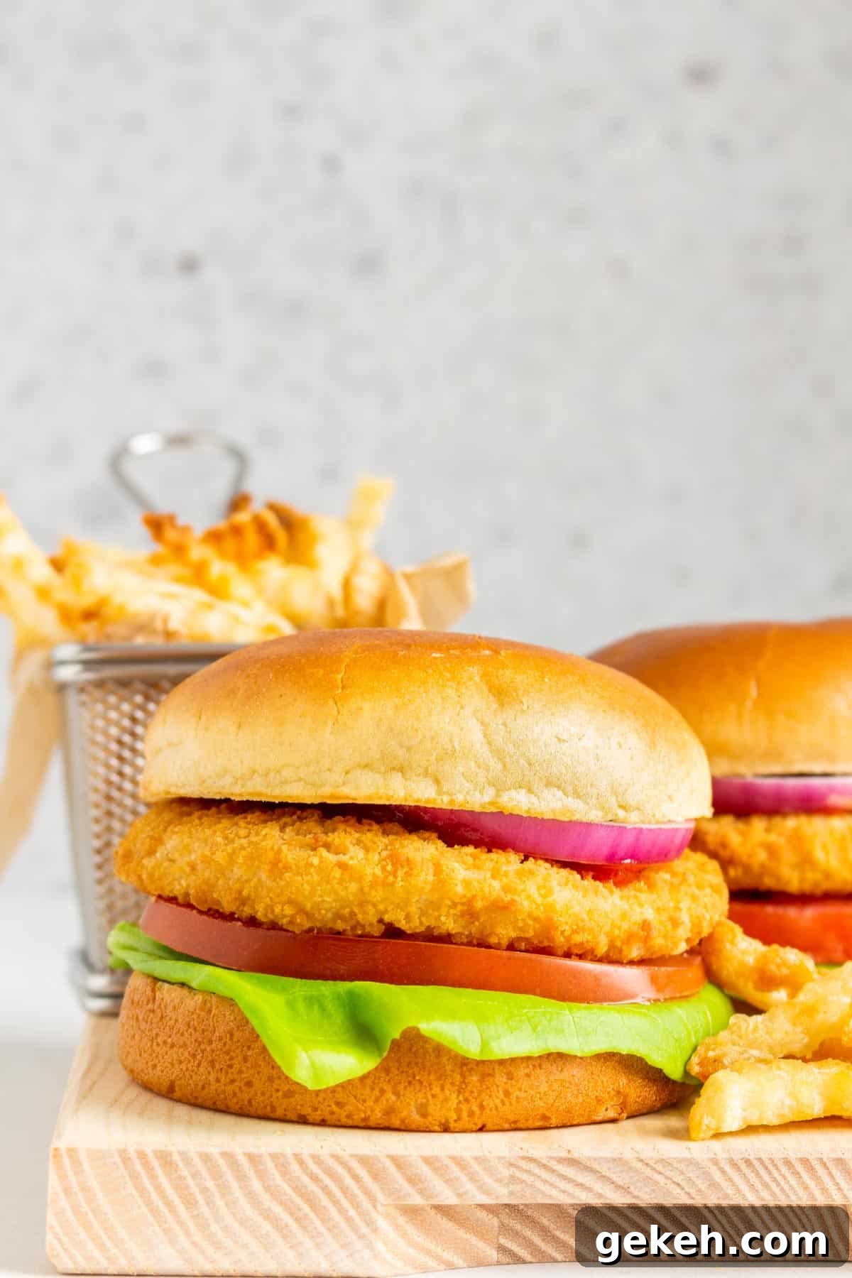 An air fryer crispy chicken sandwich surrounded by fries.