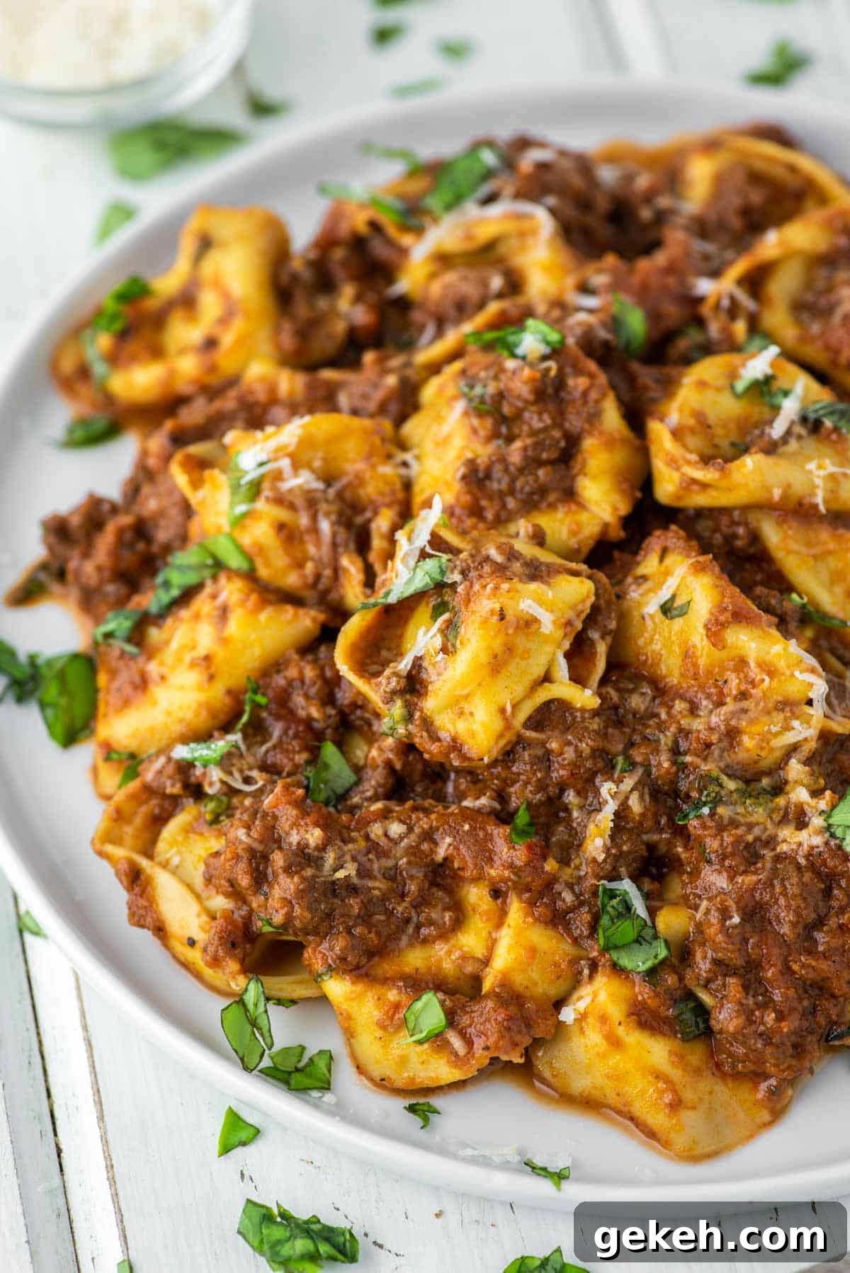 Tortellini Bolognese Recipe: Creamy Meat Sauce Pasta in 30 Minutes 3 tortellini tossed in bolognese sauce on white plate