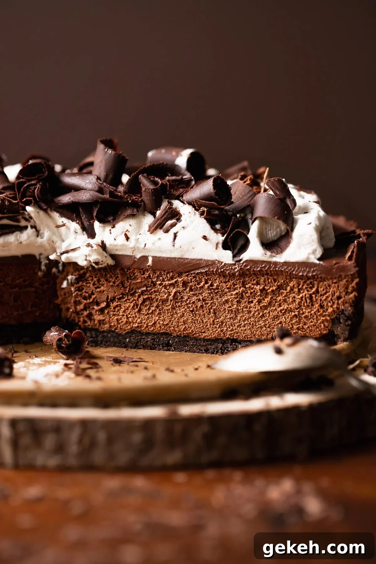 Decadent Dark Chocolate Mousse Pie Recipe for Chocolate Lovers 2 Chocolate mousse pie on a wooden platter with slices missing.