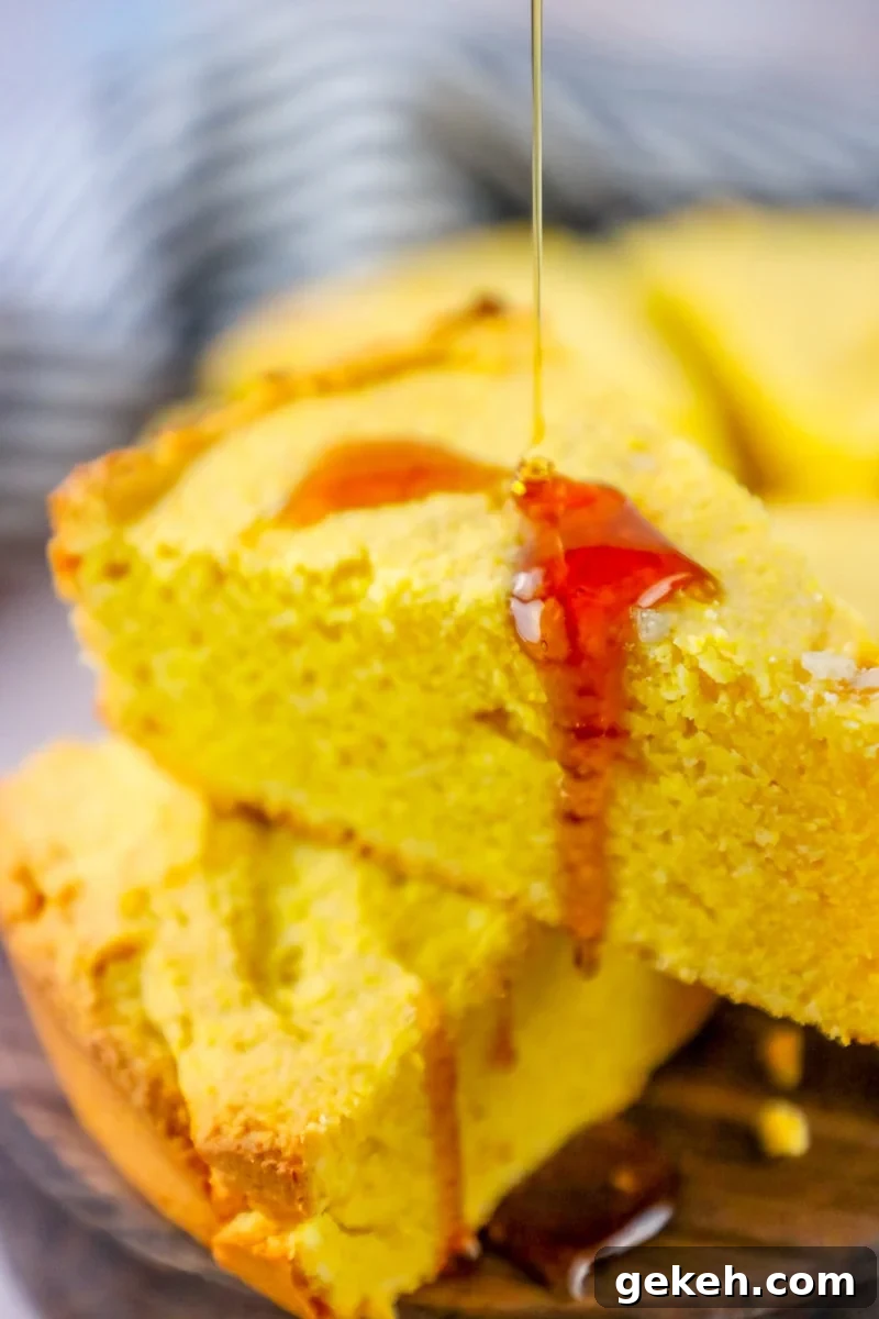 Sour Cream Cornbread Recipe: Moist Southern-Style Loaf 7 A slice of Easy Sour Cream Cornbread being drizzled with honey.