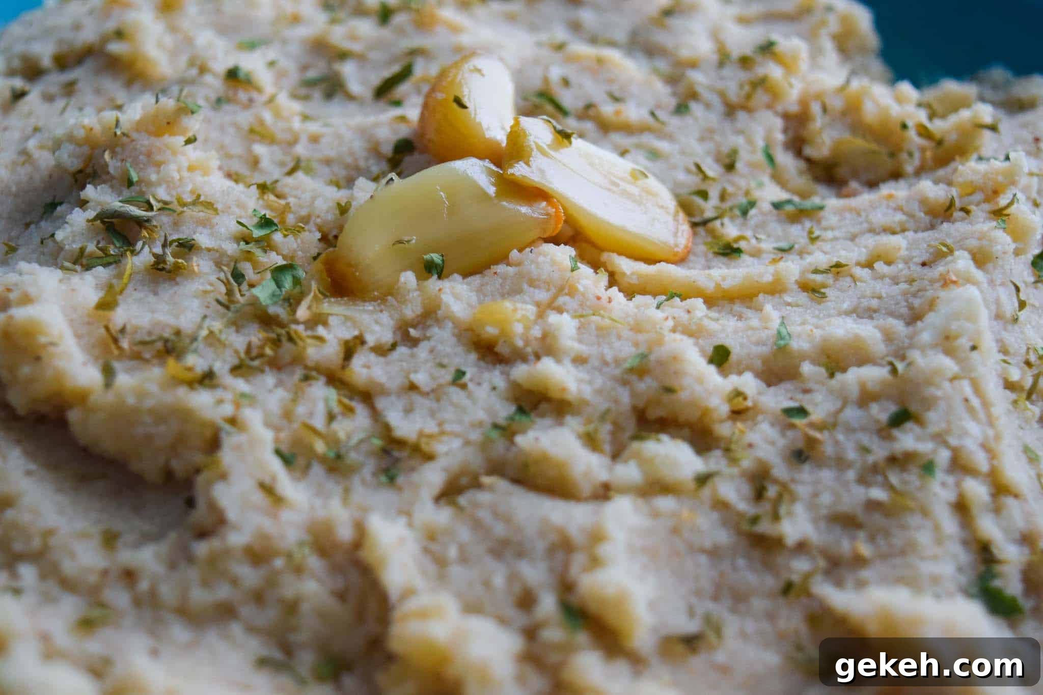 Roasted Garlic Whipped Cauliflower Recipe for Creamy Side Dish 3 roasted garlic whipped cauliflower topped with roasted garlic up close view