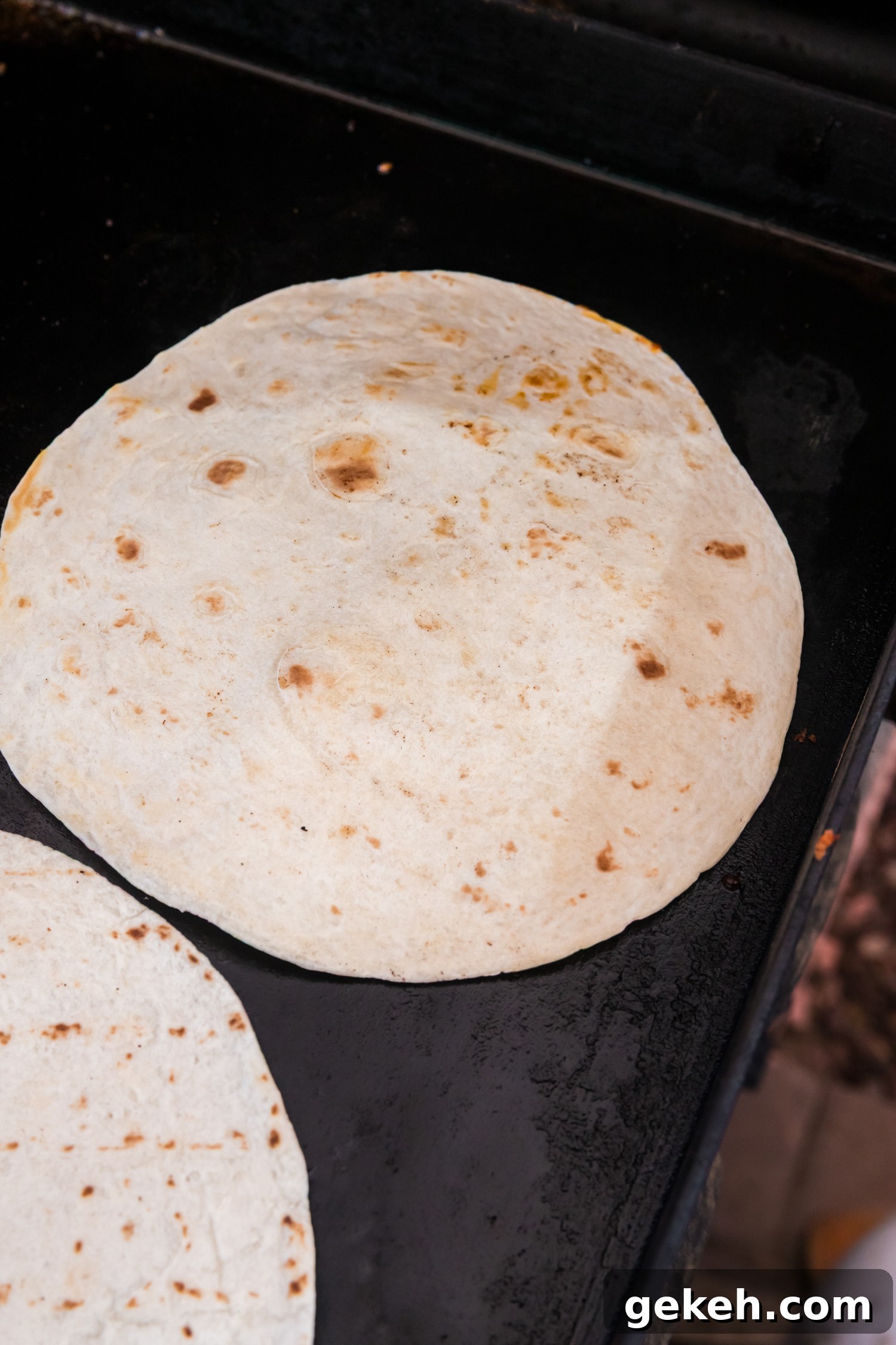 Blackstone Taco Recipe: Crispy Griddle Tacos with Charred Veggies 6 Partially cooked ground beef on a griddle topped with taco seasoning and salsa, ready to be mixed together.