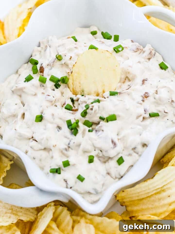 Ruffled potato chips on a plate with homemade French onion dip.