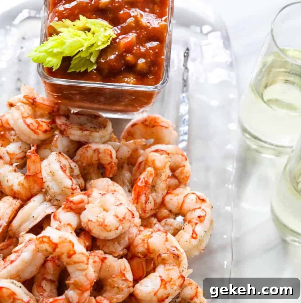 A clear glass plate with shrimp cocktail, cocktail sauce, and two glasses of champagne.