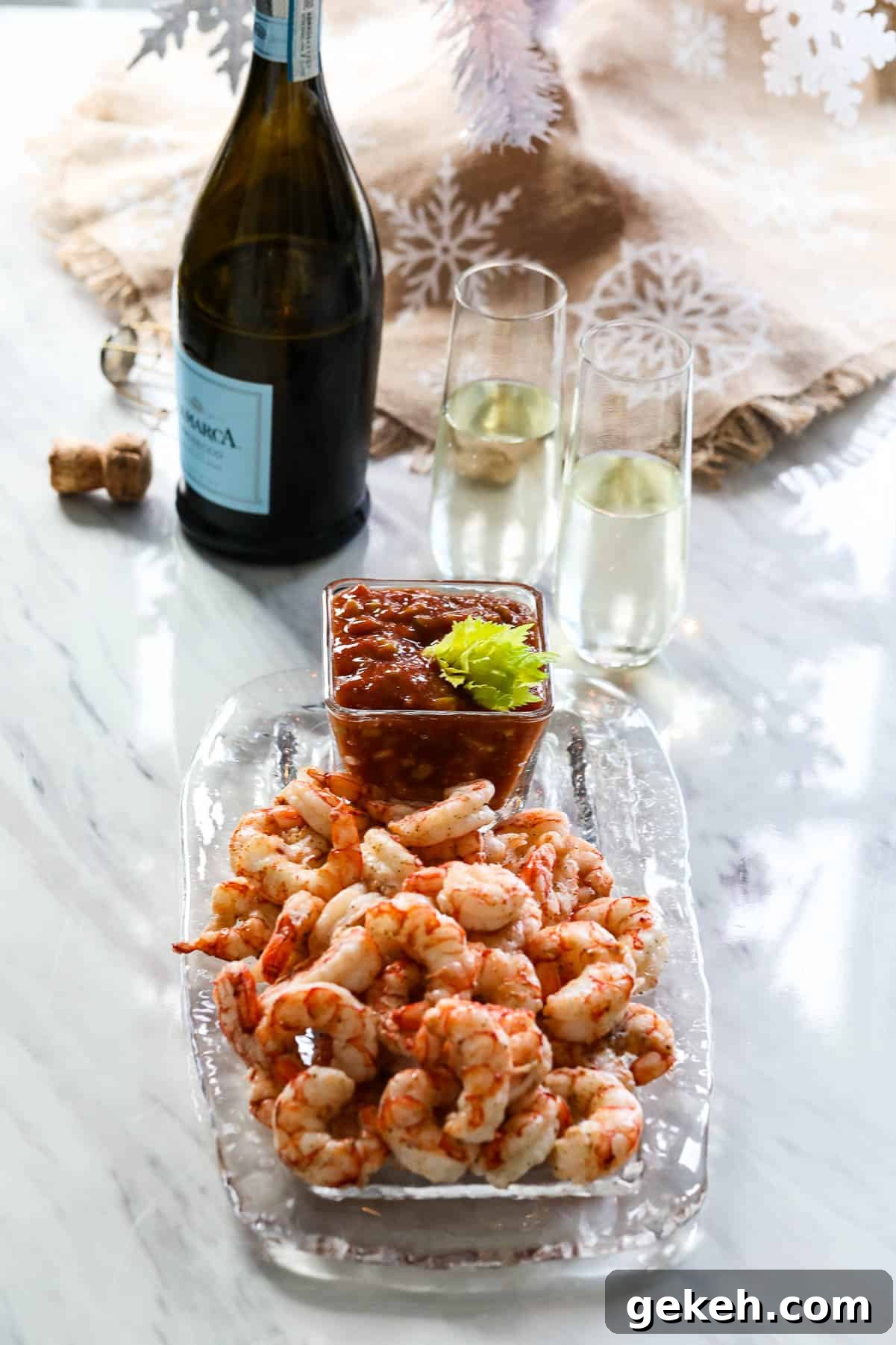 Cooked shrimp on a glass platter with cocktail to served at a Christmas party with champagne.