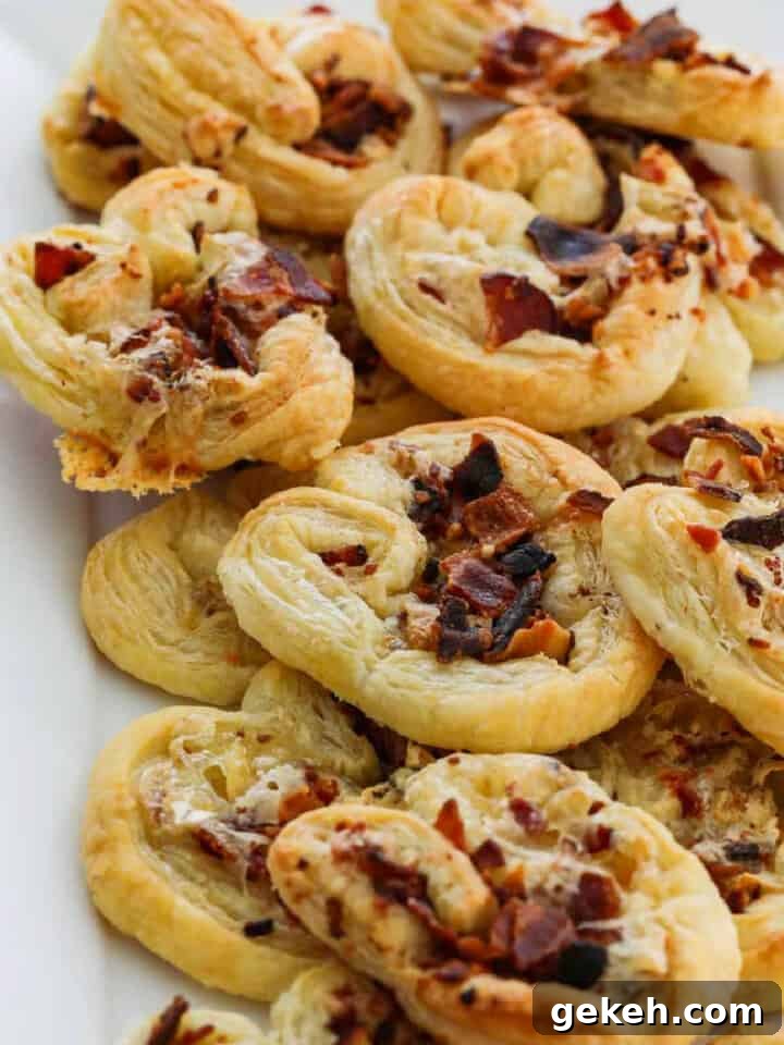 A white platter filled with brie and bacon palmier appetizers golden brown and ready to eat.