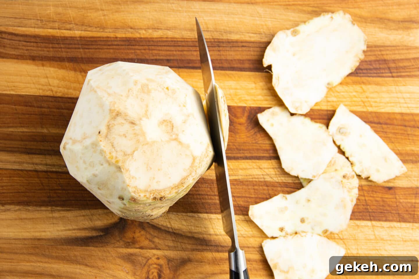 Picture of celery root being peeled with knife.
