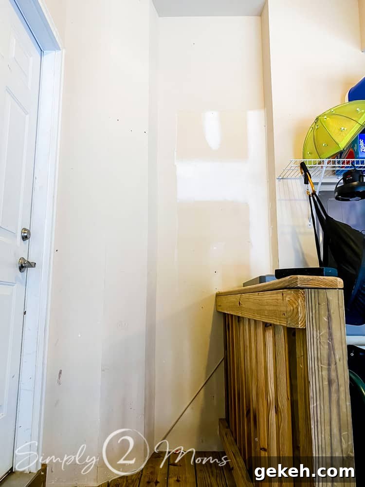 Plywood outer frame for shoe shelving in a garage attached to the wall on a stair landing into the house.