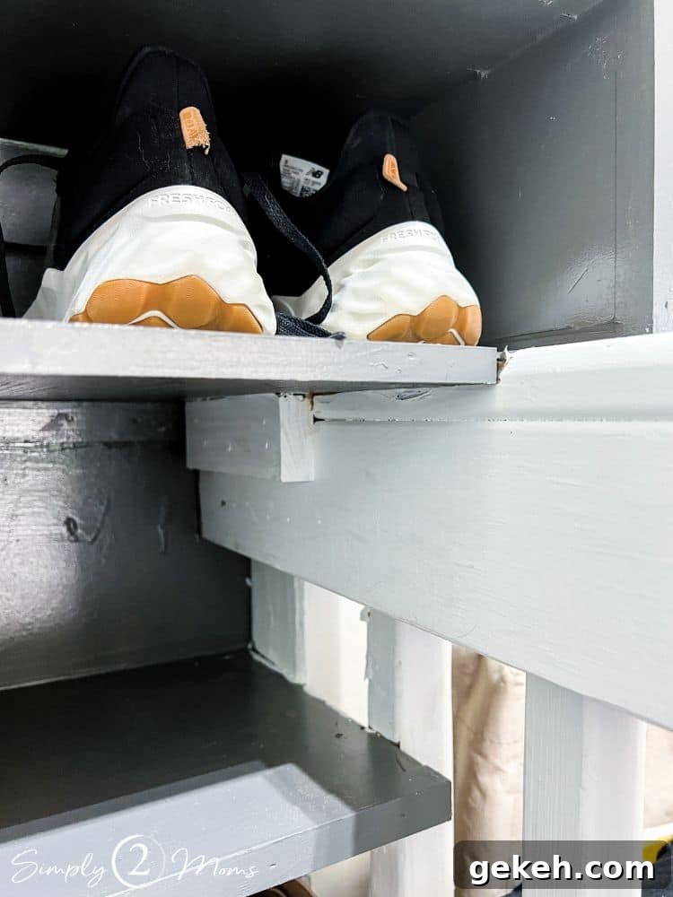 Close up of garage shoe storage shelves showing how one shelf is attached to the stair landing.