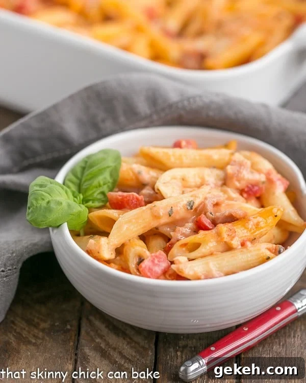 Cheesy Baked Pasta - Creamy pasta with 3 cheeses, basil and prosciutto Cheesy Baked Pasta in a white bowl garnished with fresh basil