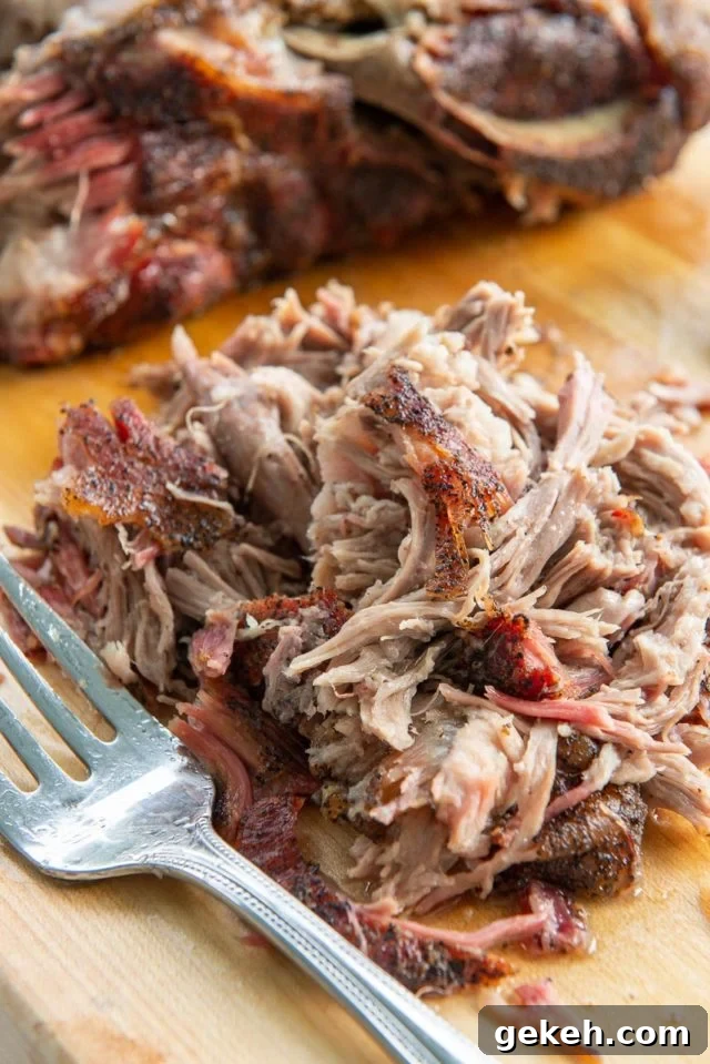Smoked Pork Shoulder - Shredded in a Pile on Wooden Board with Fork
