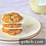 Peanut Butter Oatmeal Cookies with Reduced Sugar and Whole Oats 2 Three peanut butter, oatmeal cookies with chocolate chips stacked on top of each other on a plate.