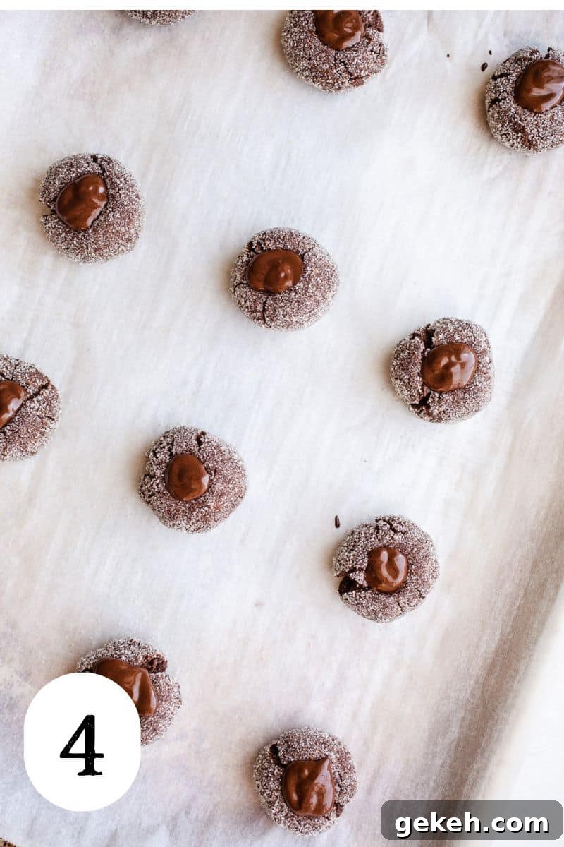 Gluten-Free Chocolate Blossom Cookies Recipe for Perfect Bakes 7 Cookies with a chocolate center on a cookie sheet.