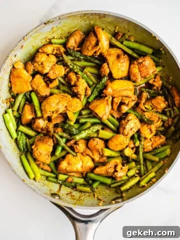 Chicken and asparagus in a pan.