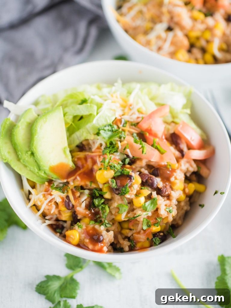 a white bowl full of instant pot chicken burrito bowl with toppings
