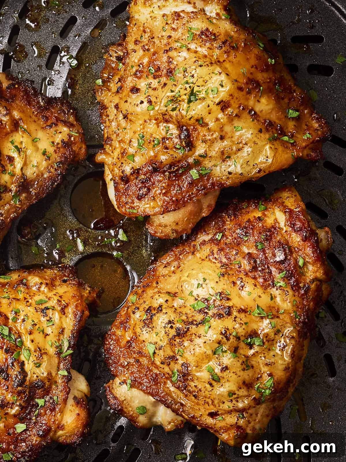 A close up of golden chicken thighs in a pan.