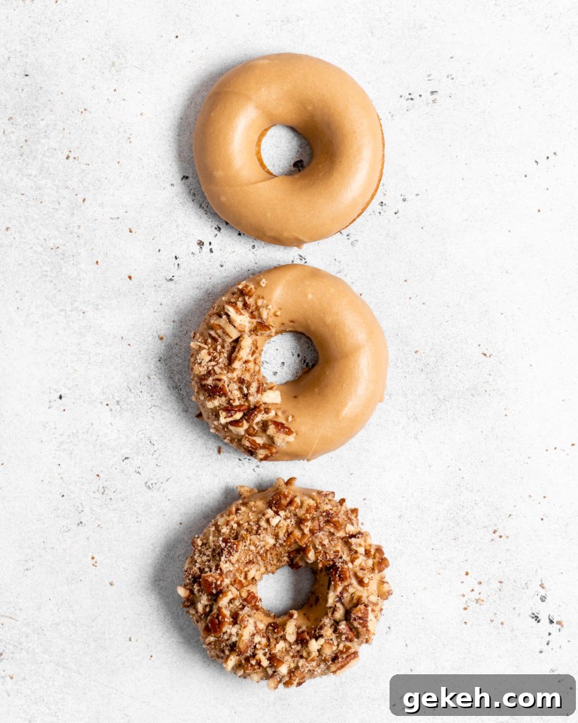Baked Spiced Brown Sugar Donuts are glazed in a butter maple glaze and garnished with a crushed pecan crust